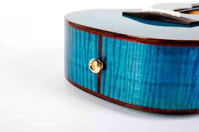 Gold strap button at base of Enya Flower ukulele